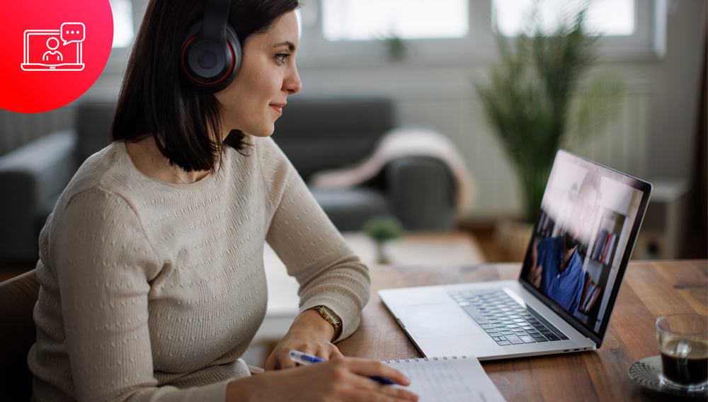 Eine Frau sitzt mit Wireless Headphones vorm Laptop und lernt ein Web Based Training